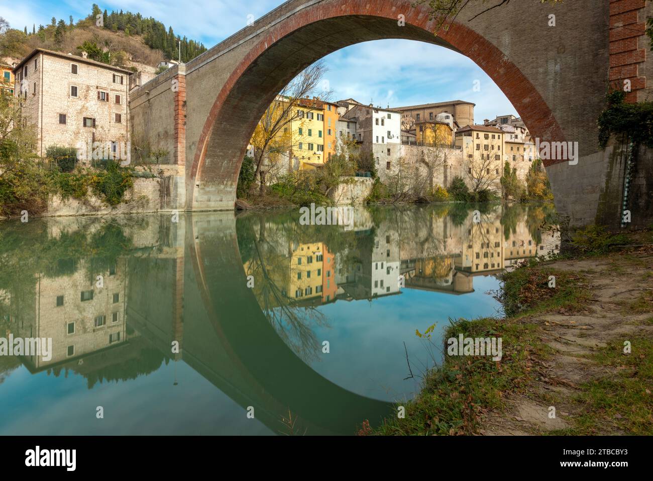 A view of Fossombrone's charming old town from the park, with the Ponte della Concordia spanning the Metauro River. Stock Photo