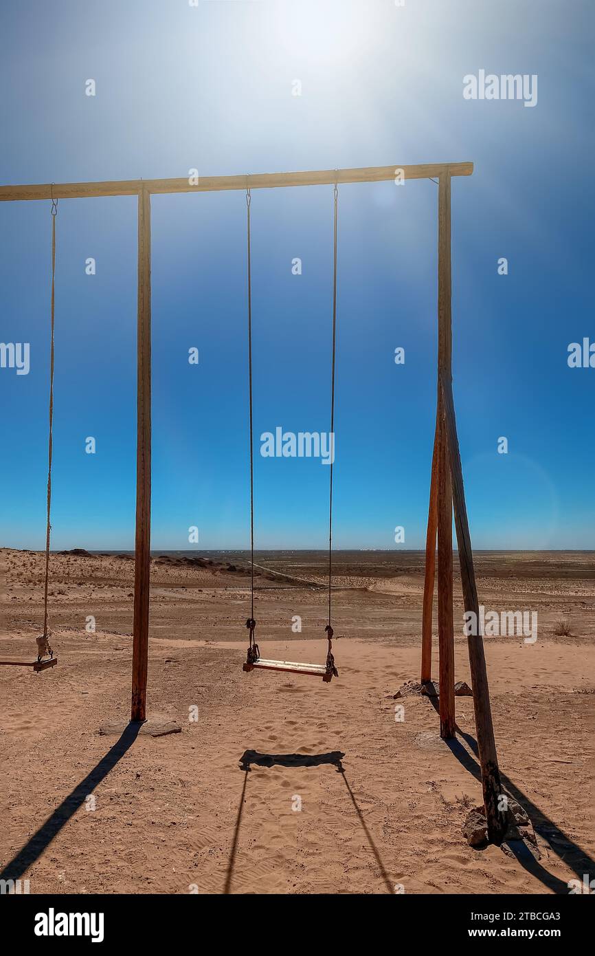 The old rope wooden swing on the desert, kyzylkum, uzbekistan Stock Photo