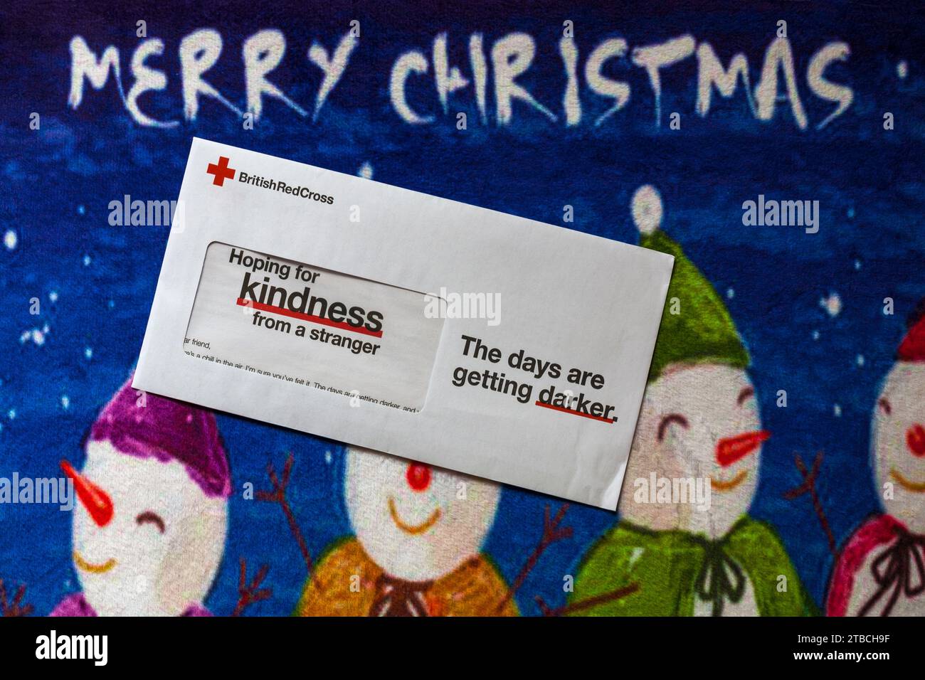 Post on Merry Christmas mat - charity appeal, Christmas appeal from British Red Cross hoping for kindness from a stranger the days are getting darker Stock Photo