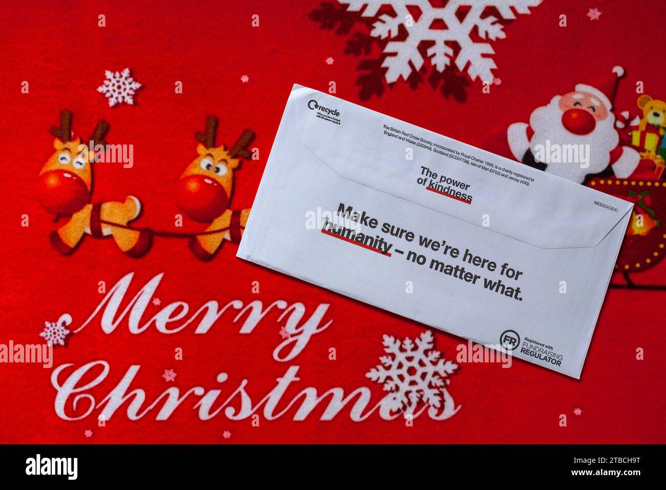 Post on Merry Christmas mat - charity appeal, Christmas appeal from British Red Cross back of envelope, the power of kindness Stock Photo