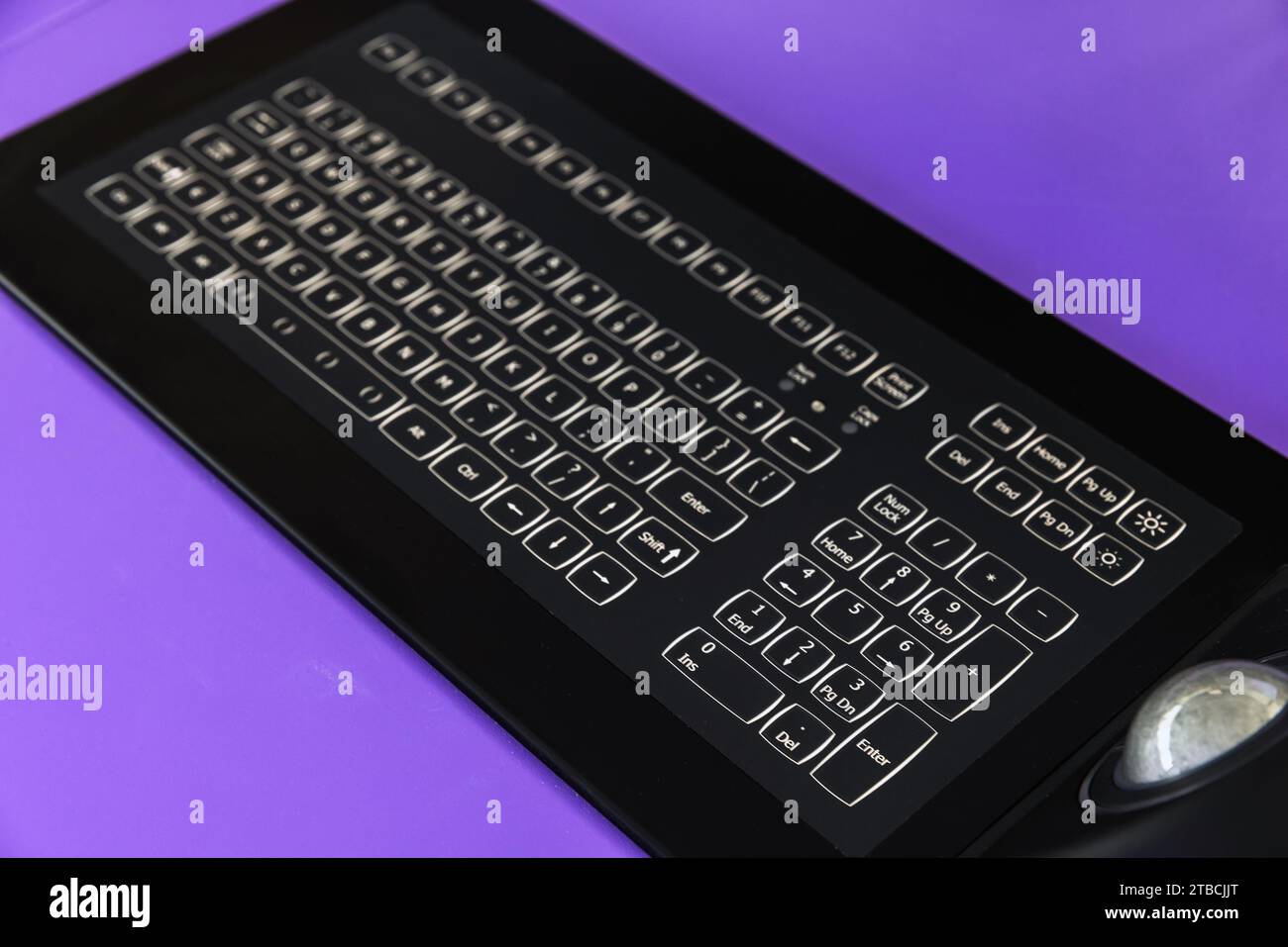 Built-in tabletop input device with black industrial keyboard with trackball mouse, modern navigation equipment mounted on a captains bridge Stock Photo