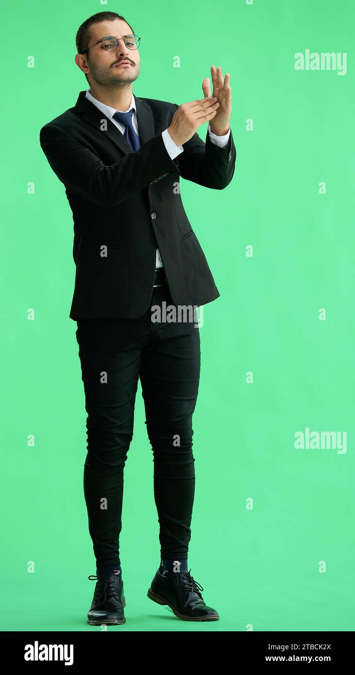 young man in full growth. isolated on green background shows timeout Stock Photo