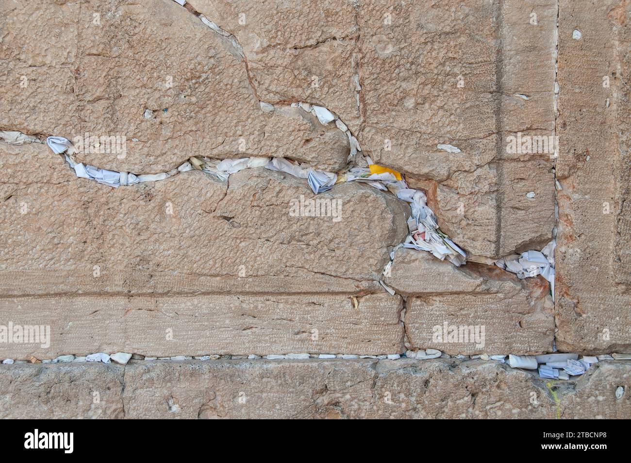 Tiny, folded pieces of paper with written notes addressed to God are crammed into cracks