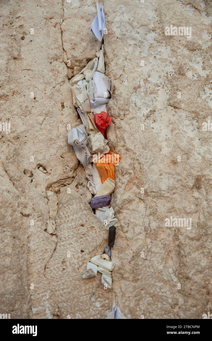 Tiny, folded pieces of paper with written notes addressed to God are crammed into cracks