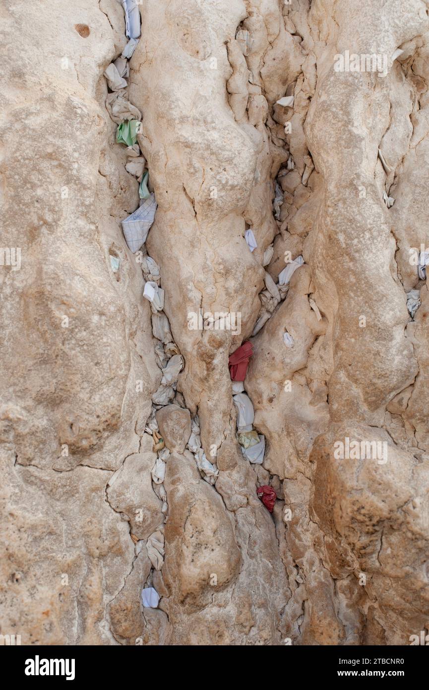 Tiny, folded pieces of paper with written notes addressed to God are crammed into cracks