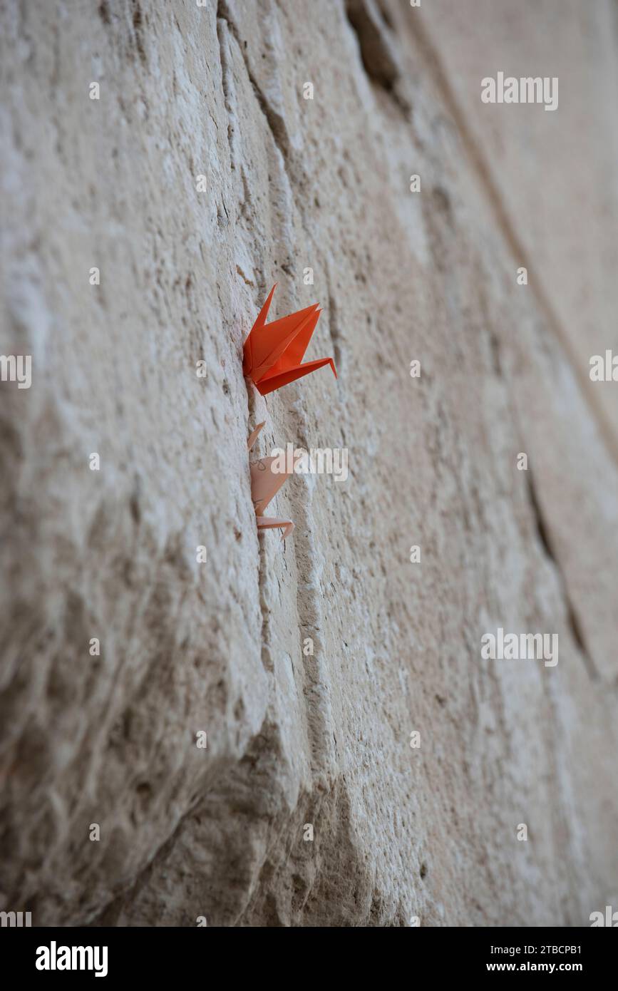 Tiny, folded pieces of paper with written notes addressed to God are crammed into cracks