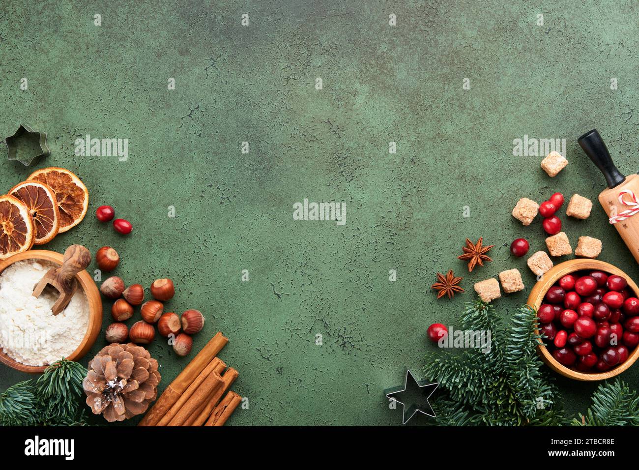 Christmas culinary background with ingredients for cooking christmas baking cranberries, sugar, cinnamon and Christmas tree branches on old green conc Stock Photo