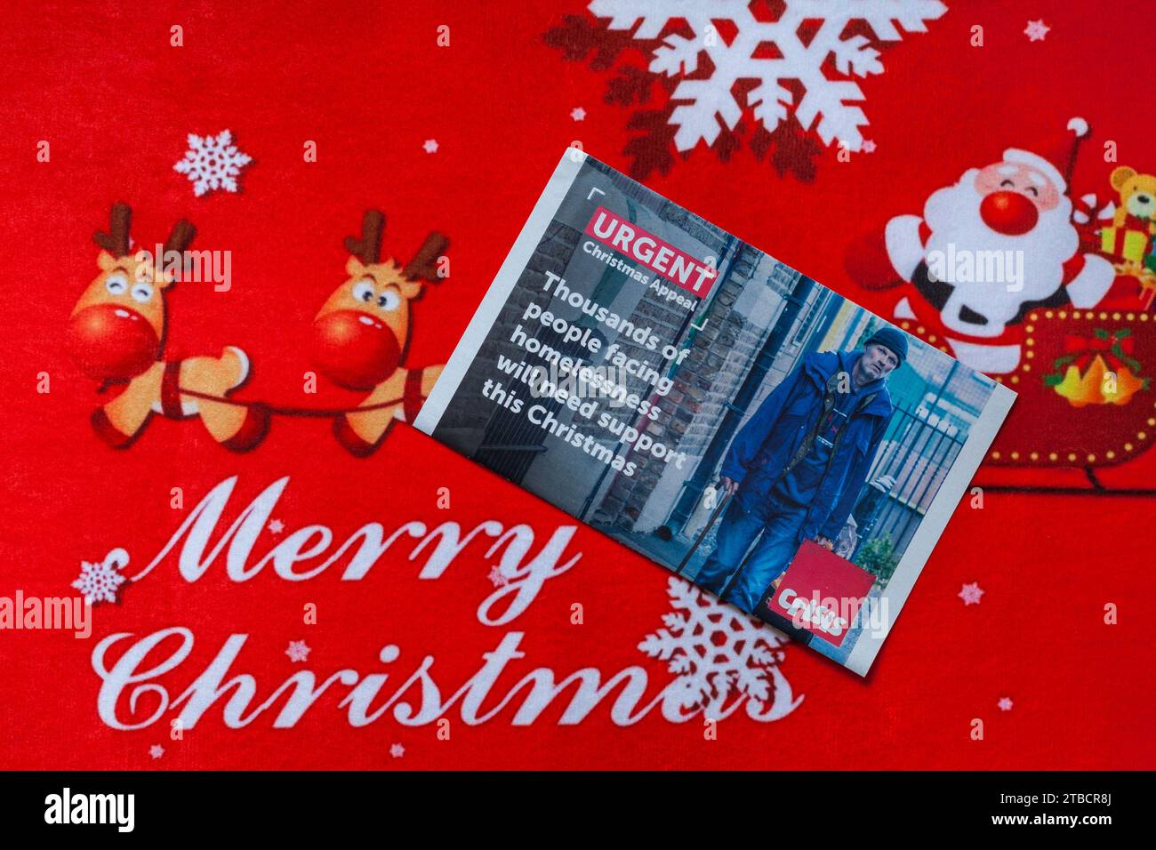 Post on Christmas mat, Merry Christmas - charity appeal from Crisis - thousands of people facing homelessness will need support this Christmas Stock Photo