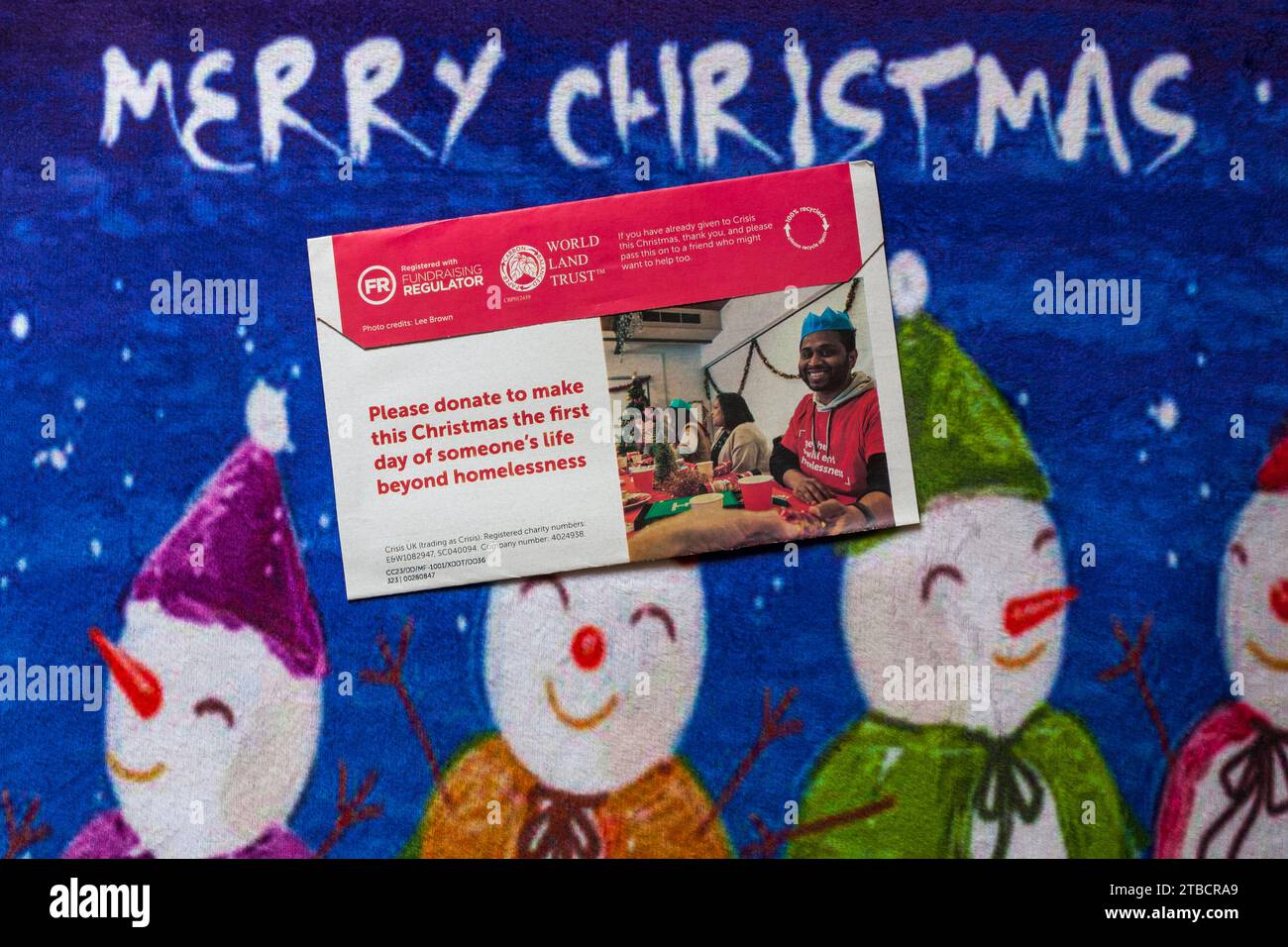 Post on Christmas mat - charity appeal from Crisis back of envelope  - Merry Christmas Stock Photo