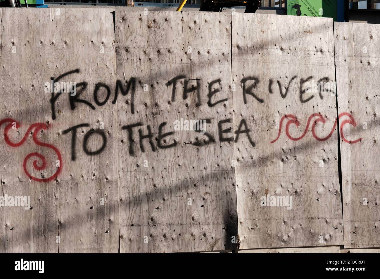 'From The River To The Sea' graffiti on construction board Stock Photo
