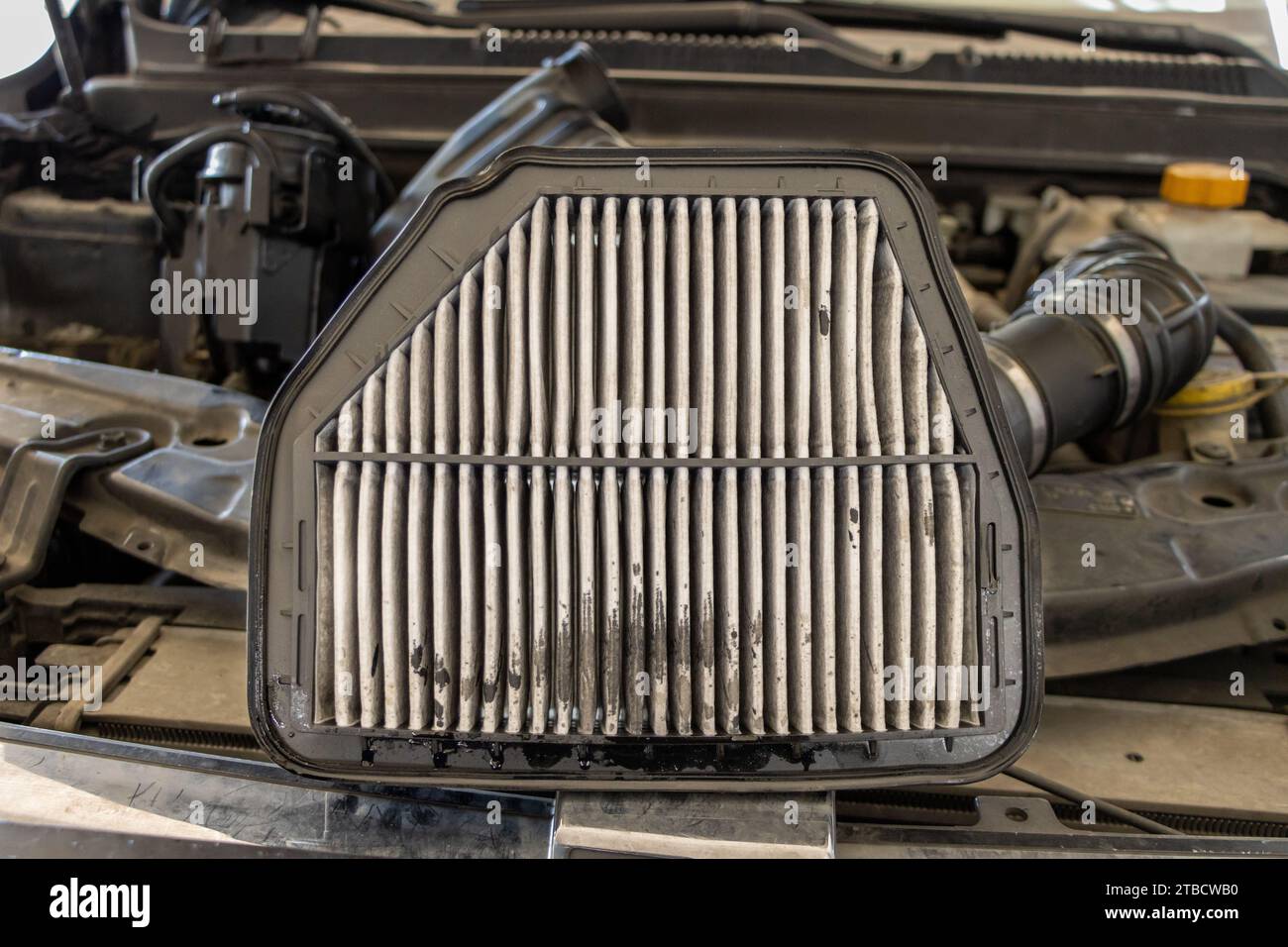 Car air filter replacement. changing a old air filter in cars engine. Mechanic replaces dirty air filter and installs new filter. Vehicle maintenance Stock Photo