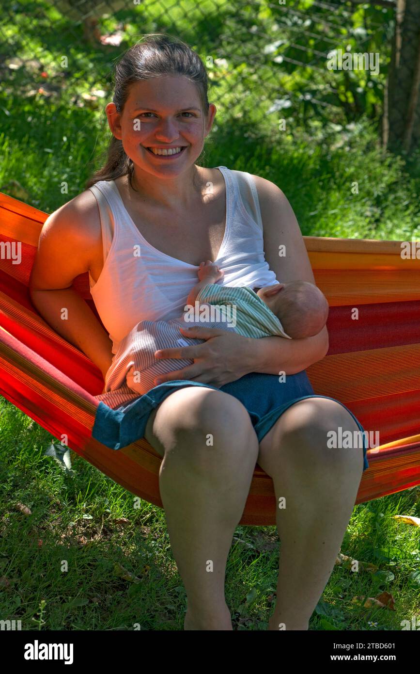 Young mother with baby in a hammock in the garden, Mecklenburg-Vorpommern, Germany Stock Photo