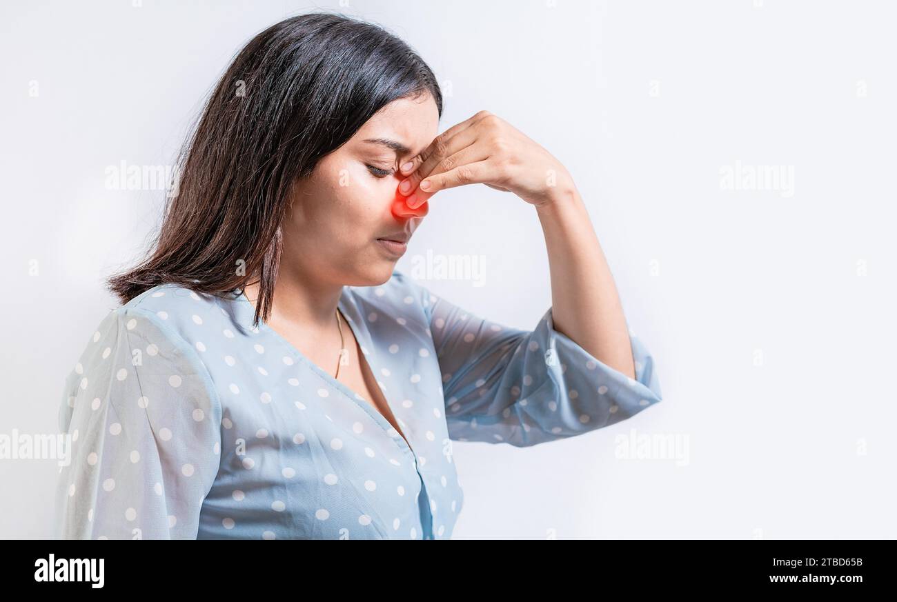 Young woman with pain touching nose. Person with nasal bridge pain, Girl with nasal bridge headache. Sinus pain concept Stock Photo