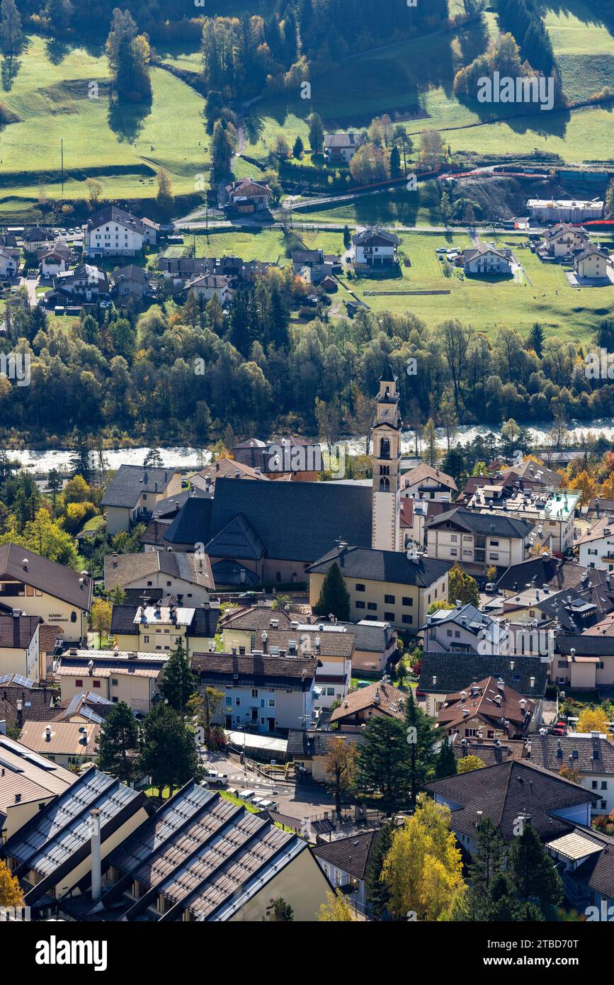 Village scene with Chiesa parrocchiale di S.Eliseo and Torrente Avisio torrent, Tesero, Trentino, Italy Stock Photo