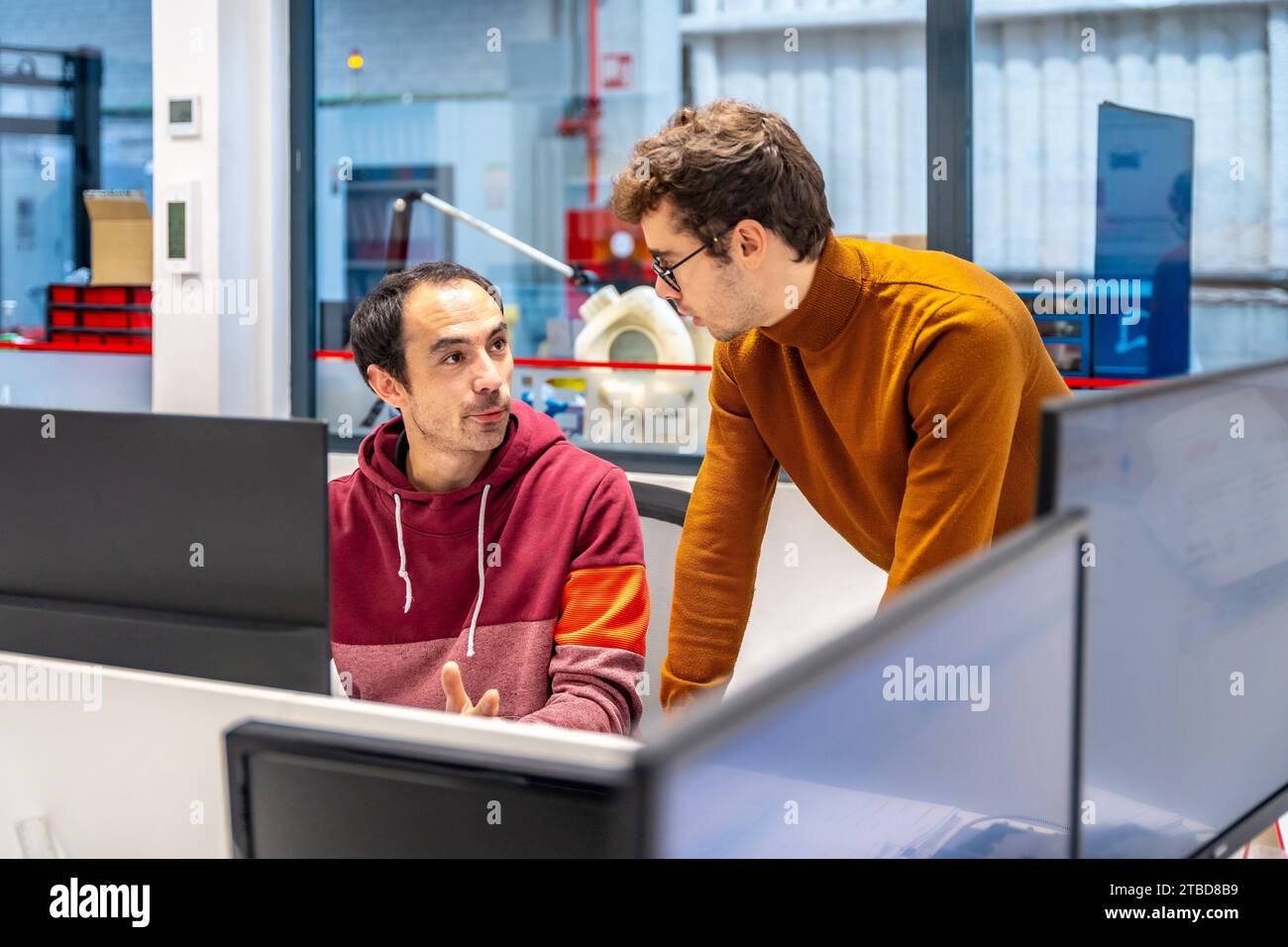 Two male technicians using computer in a cnc modern factory office Stock Photo