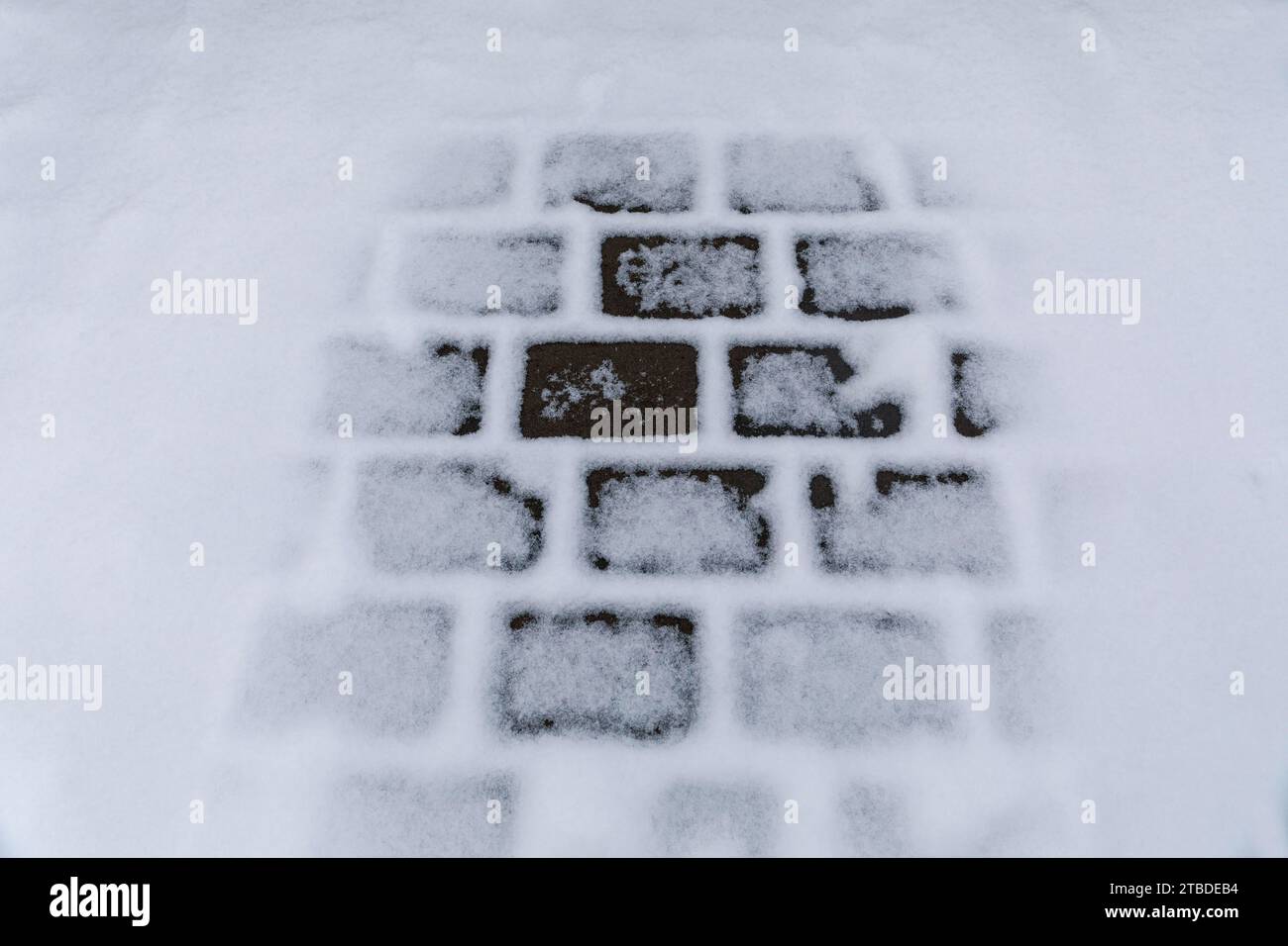 Thawing snow on a cobblestone path Stock Photo