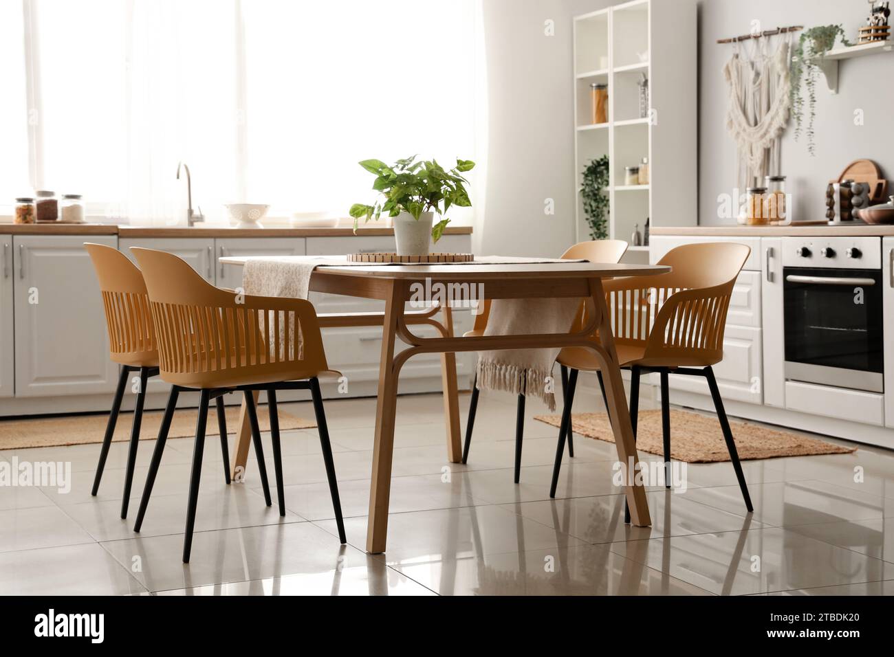 Interior of light kitchen with white counters and dining table Stock ...