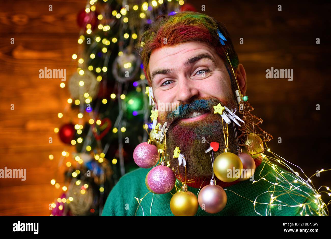 Christmas beard decorations. Closeup portrait of smiling man with decoration balls in beard. Merry Christmas and Happy New year. Happy bearded man Stock Photo