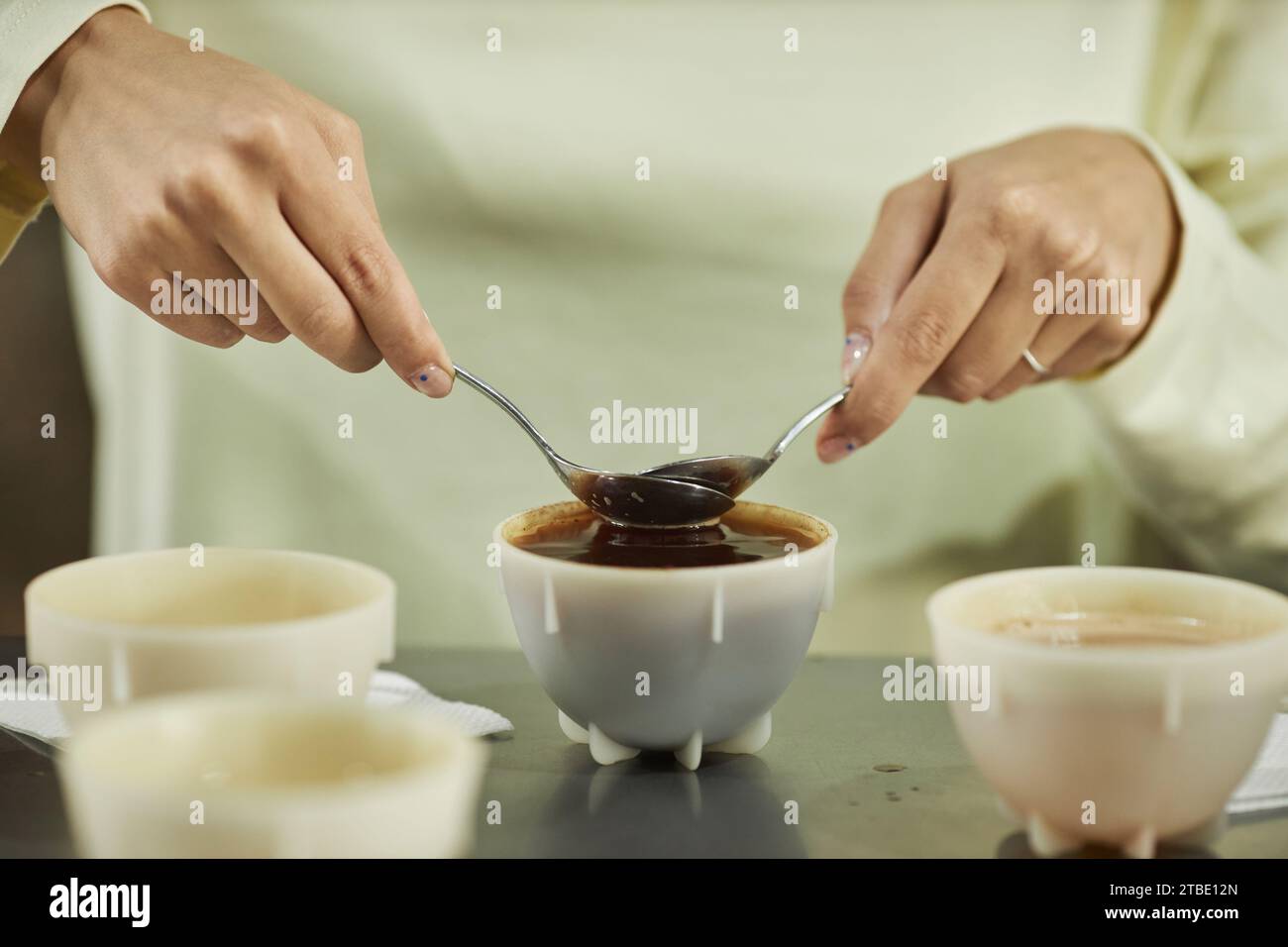 Close up of unrecognizable woman carefully removing foam from coffee ...
