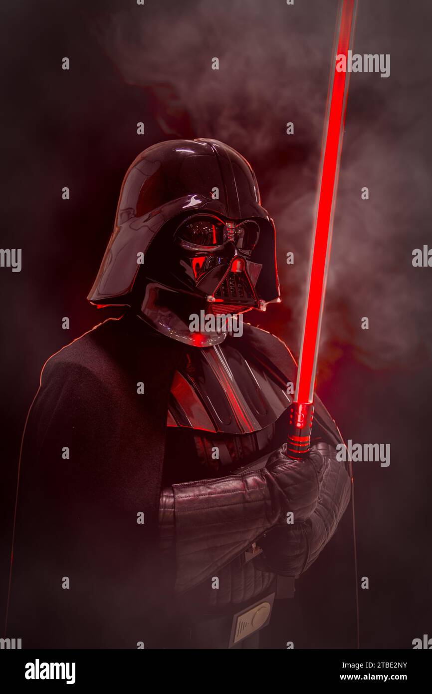 NEC, BIRMINGHAM, UK - DECEMBER 3, 2023.  A male cosplay at a comic con event in Darth Vader costume from Star Wars holding a red lightsaber in a drama Stock Photo