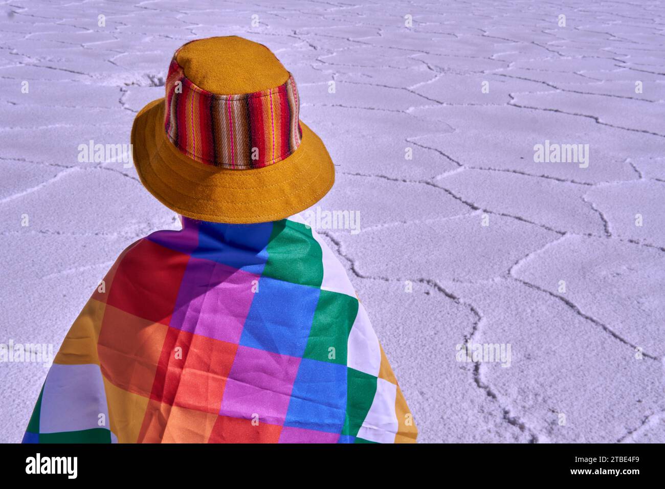 portrait of an Argentinian child belonging to the native peoples with a wiphala flag on his back in Salinas Grandes Jujuy. Salt flat in Argentina Stock Photo