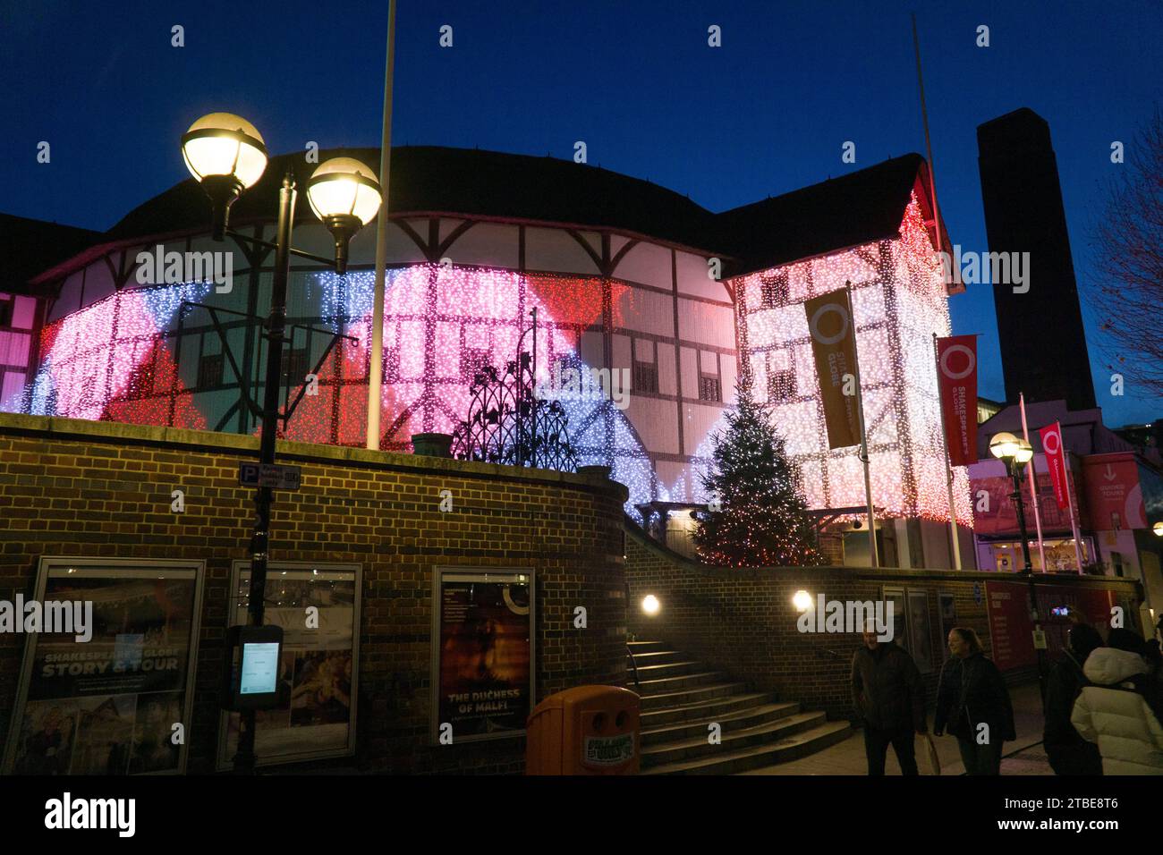 UK weather, 6 December, London: At dusk on a cold but clear day, Shakespeare's Globe theatre puts on a display of changing fairy lights, with the tower of Tate Modern seen in the background against a dusk sky. Credit: Anna Watson/Alamy Live News Stock Photo