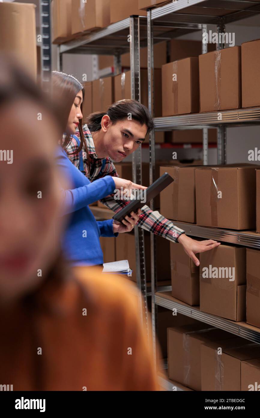 Warehouse employees inspecting parcels on rack and doing inventory