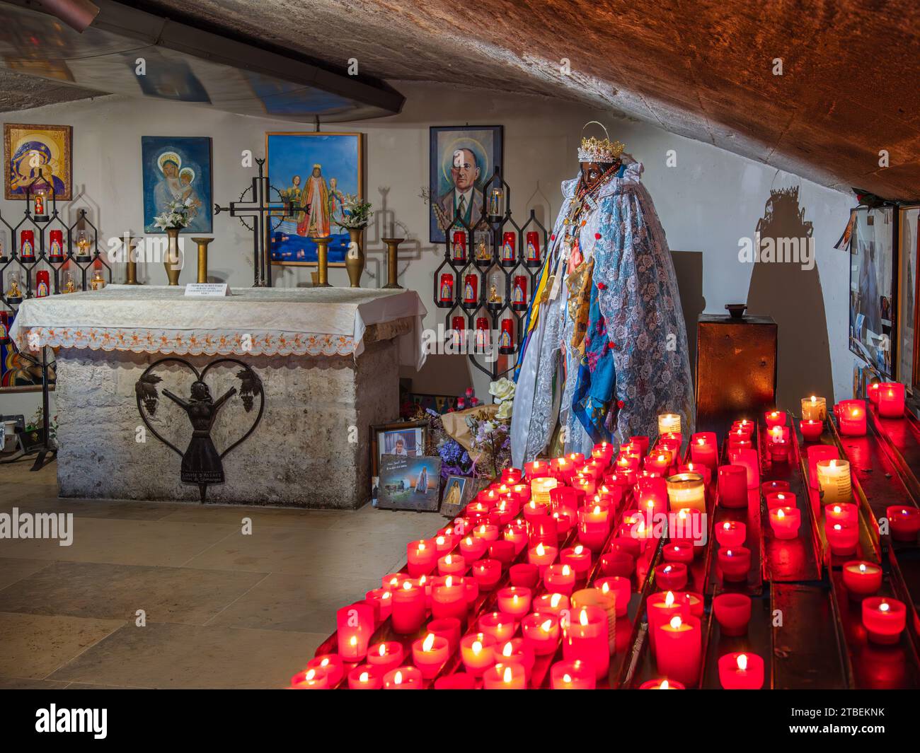 Saintes Maries de la Mer, France - October 3, 2023: Votive candles burn in front of the statue of Saint Sarah, the patron saint of gipsies, in the cry Stock Photo