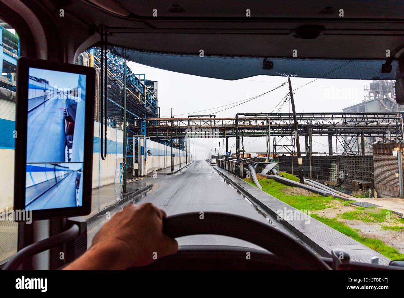 View from inside a truck of a street in an industrial estate, vehicle with rearview mirror for cameras. Stock Photo