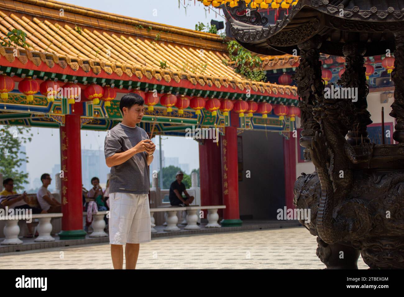 A person praying with incenses at the Thean Hou Temple,  one of the largest and oldest Buddhist temples in Southeast Asia at Kuala Lumpur, Malaysia Stock Photo