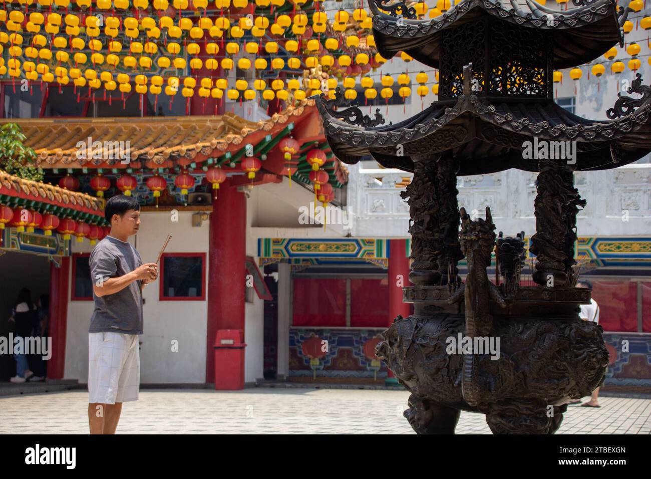 A person praying with incenses at the Thean Hou Temple,  one of the largest and oldest Buddhist temples in Southeast Asia at Kuala Lumpur, Malaysia Stock Photo