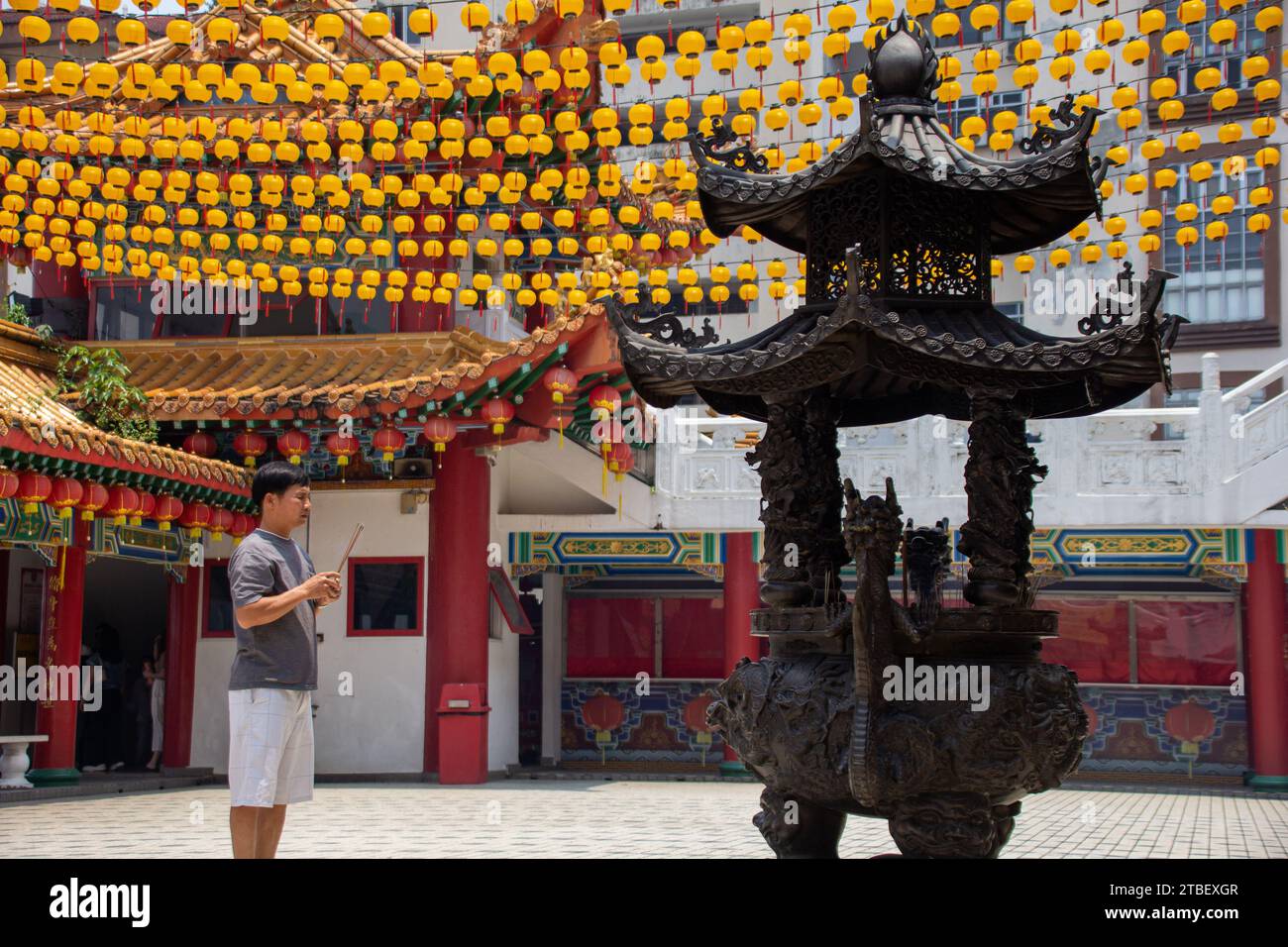 A person praying with incenses at the Thean Hou Temple,  one of the largest and oldest Buddhist temples in Southeast Asia at Kuala Lumpur, Malaysia Stock Photo