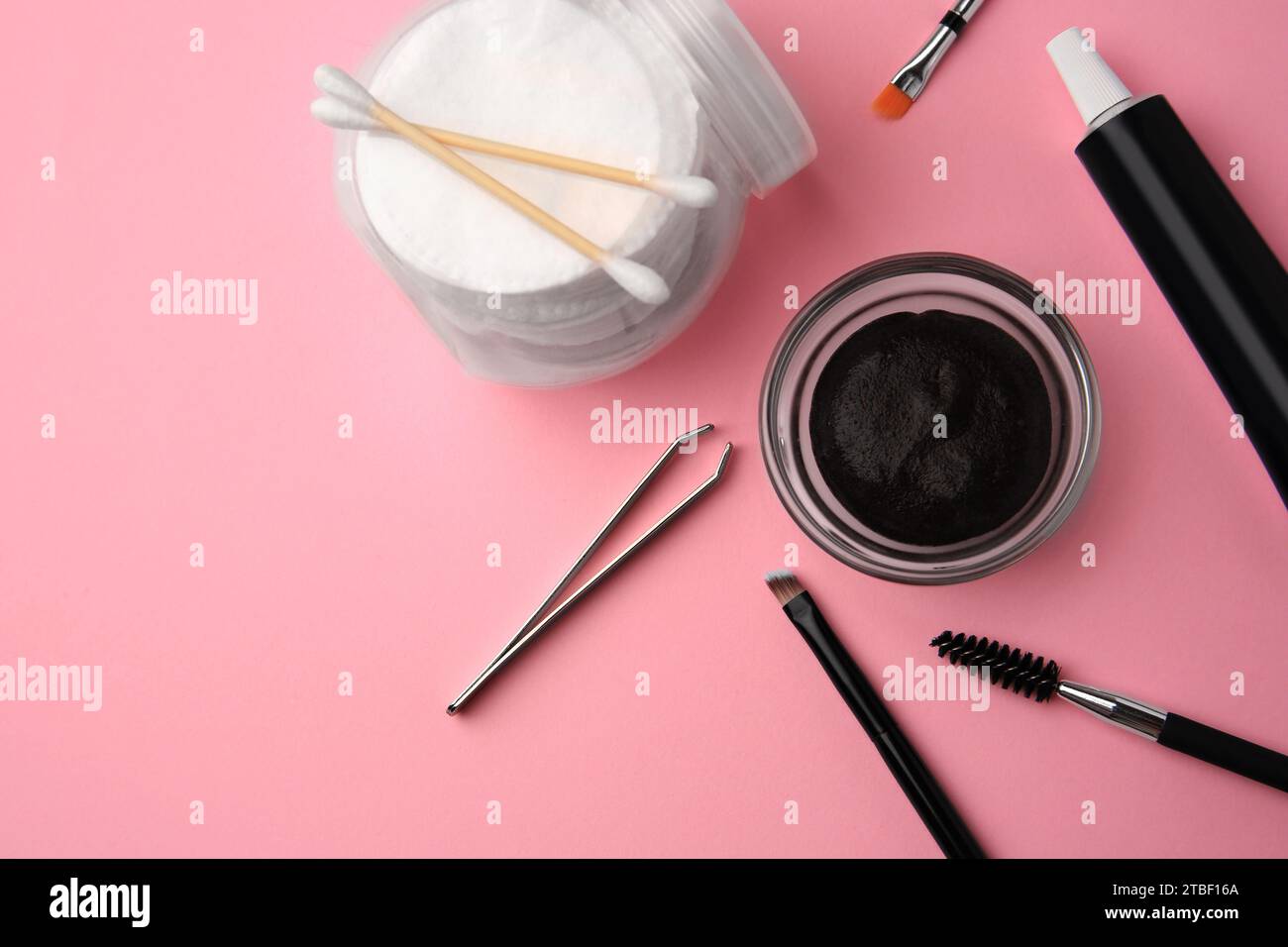 Flat lay composition with eyebrow henna and tools on pink background. Space for text Stock Photo