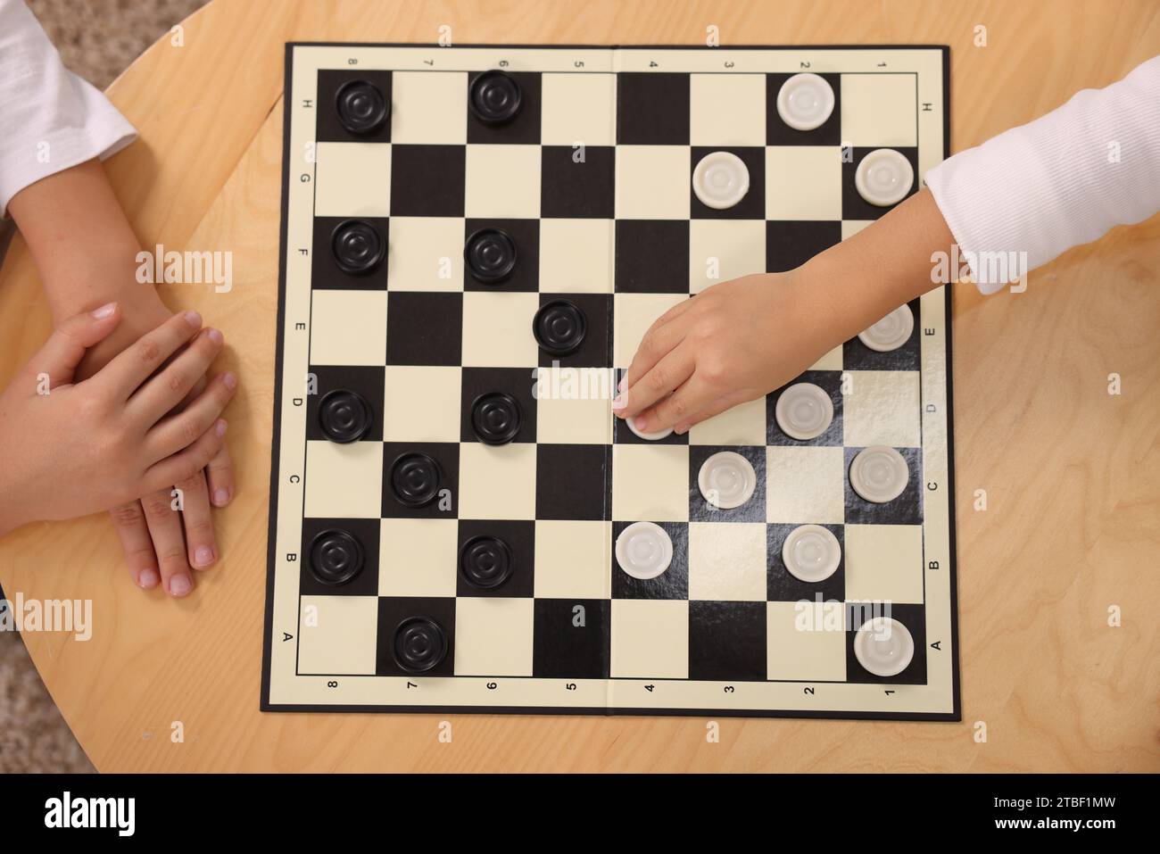 Children playing checkers at coffee table, top view Stock Photo - Alamy
