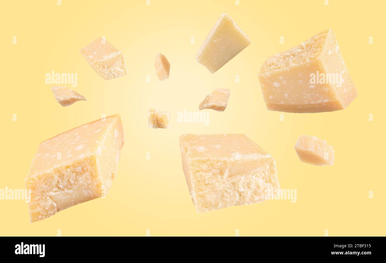 Parmesan cheese in air on pale yellow background, banner design Stock Photo