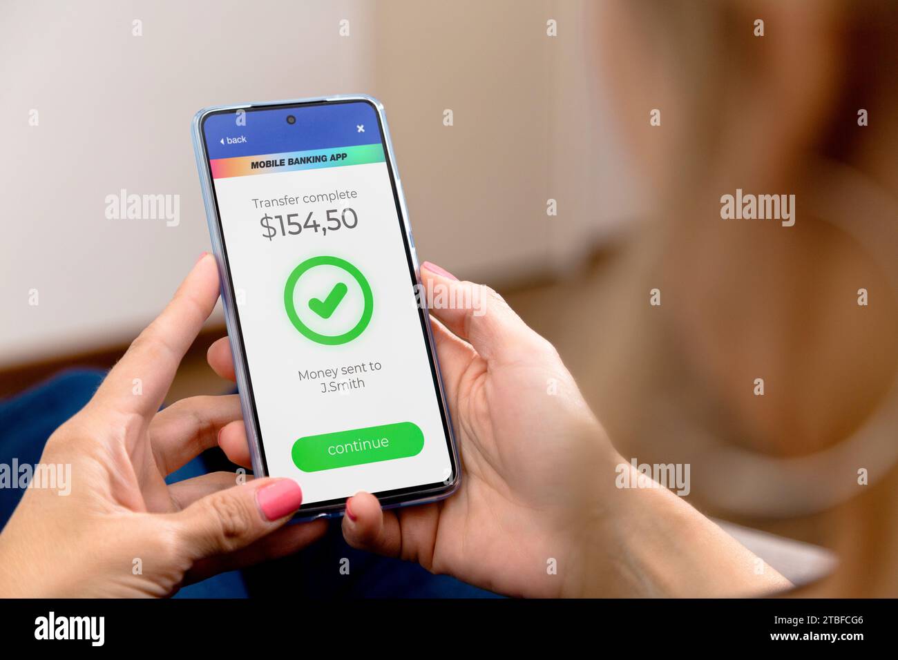 Online transaction complete. Woman holding a mobile phone with a financial application on screen.A person who transfers money online using application Stock Photo