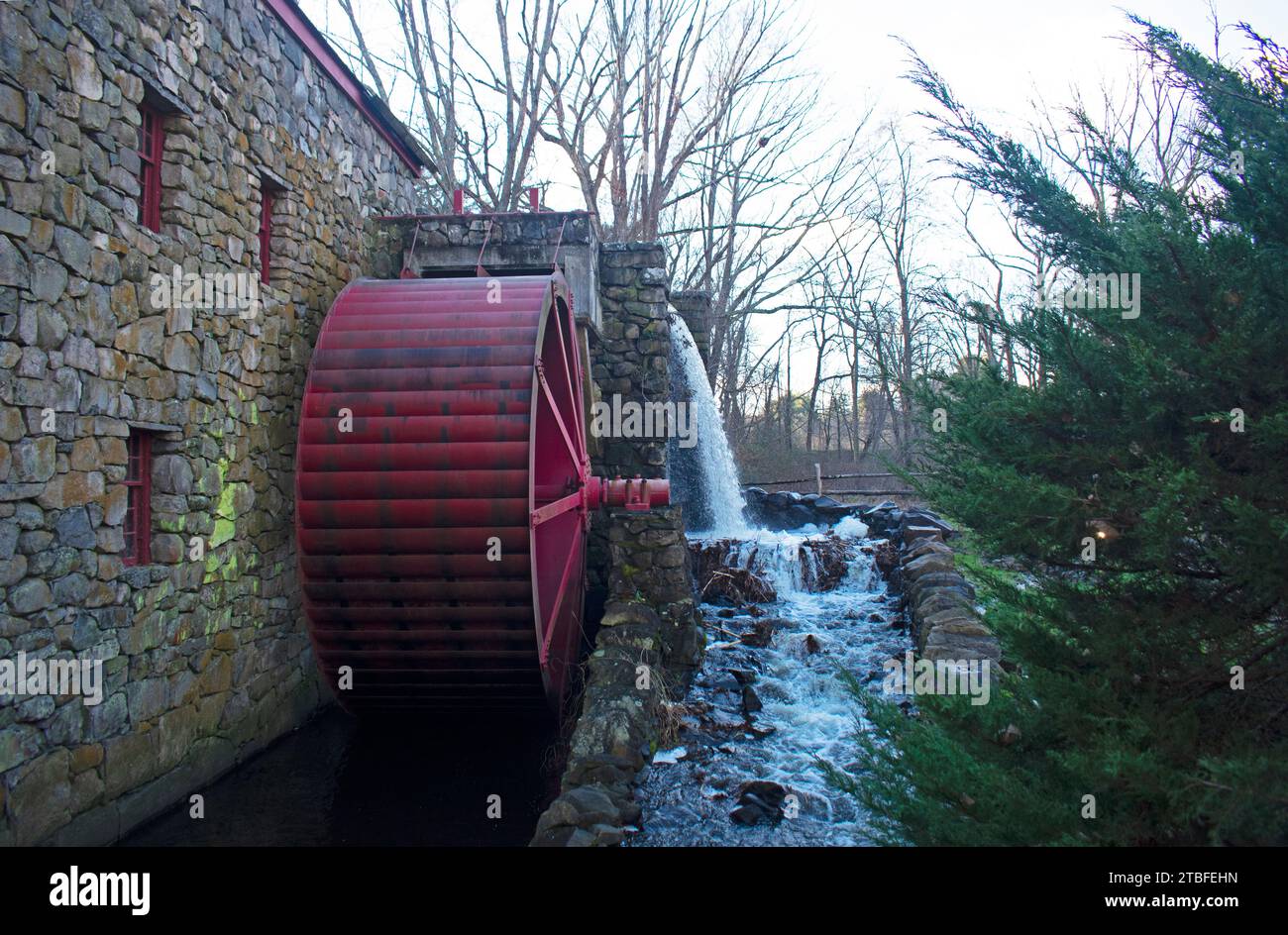 Historic landmark grist mill sporting a red wooden wheel, in Sudbury, Massachusetts, that is still in operation, producing cornmeal and wheat flour -0 Stock Photo