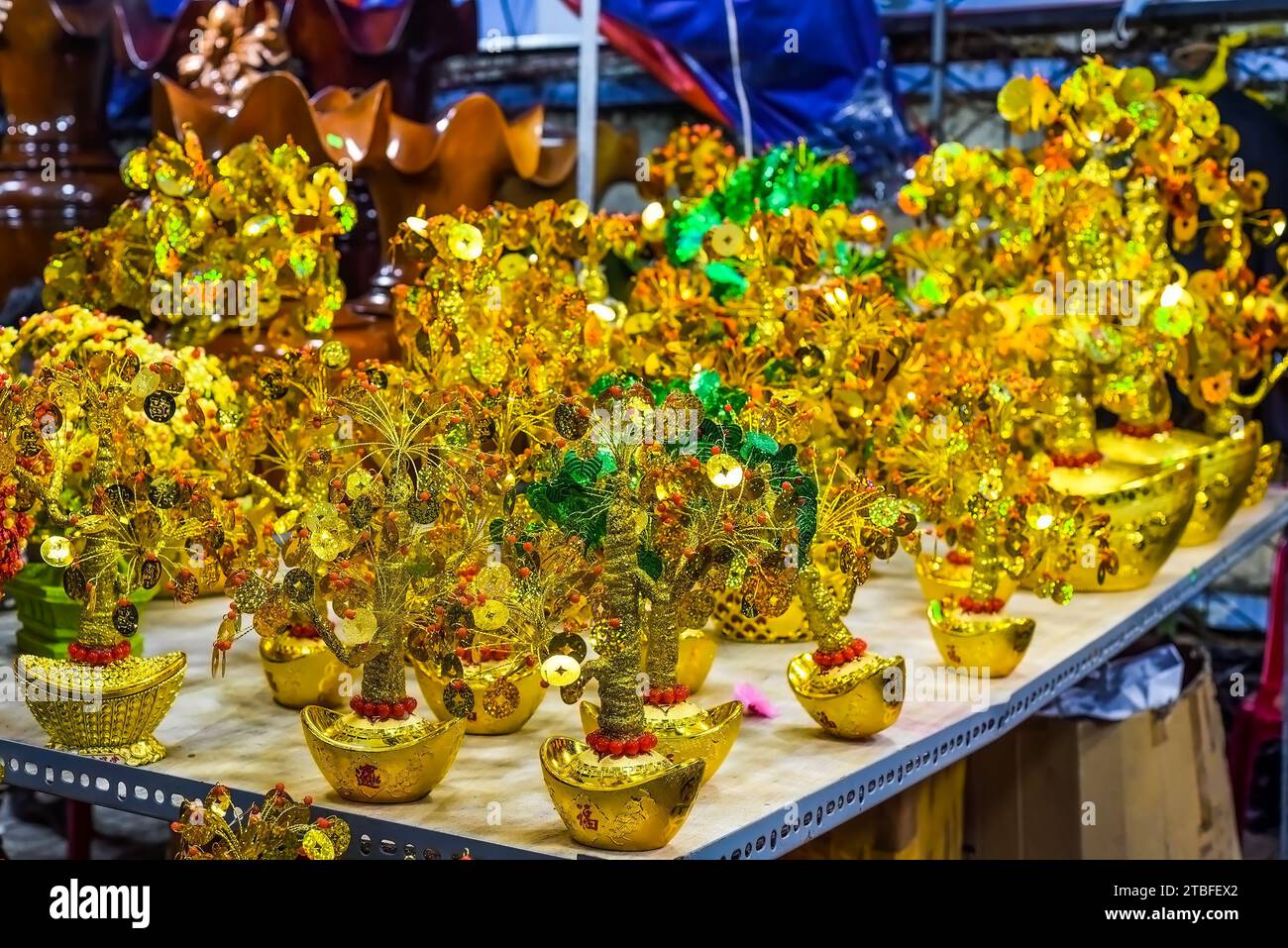 many decorations as symbol of wealth in the market for Tet Lunar New Year with text translated as 'Happy New Year' in vietnamese Stock Photo