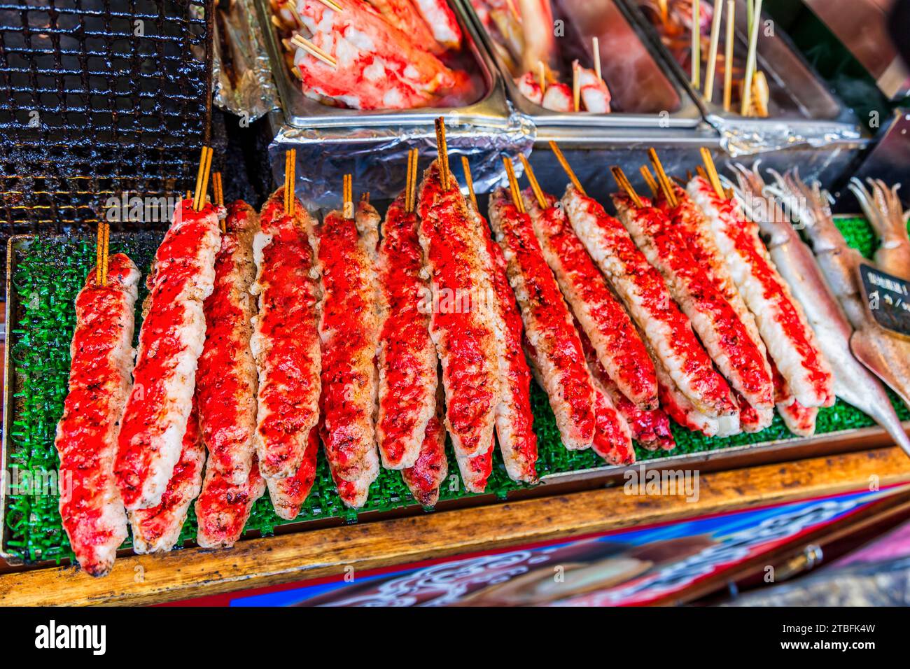 Street food stall with cooked seafood crab meat on skewers in japan at popular tourist shopping