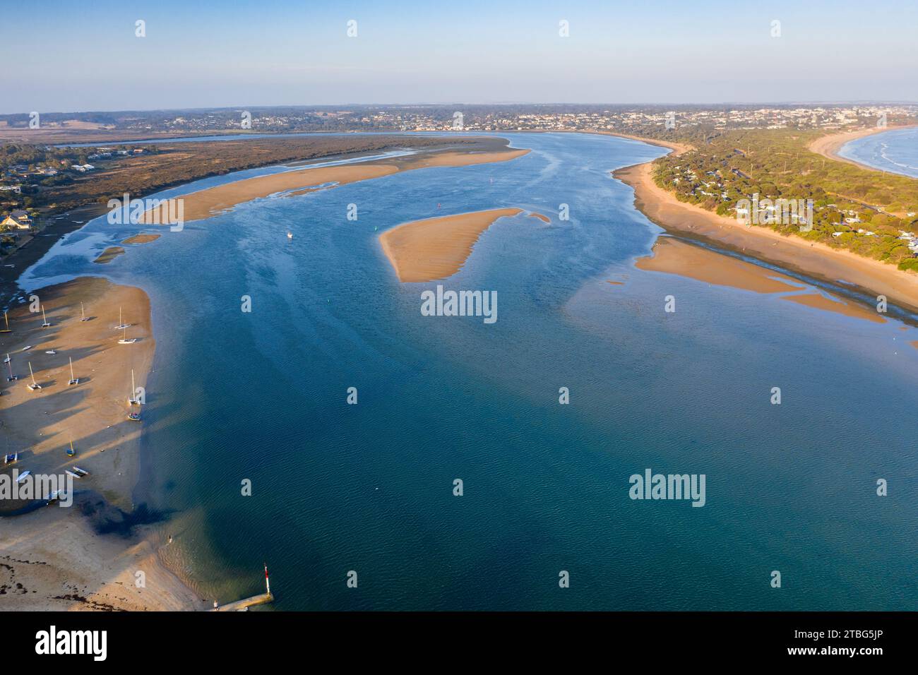 Aerial view of sandbars and beaches along the sides of a wide coastal