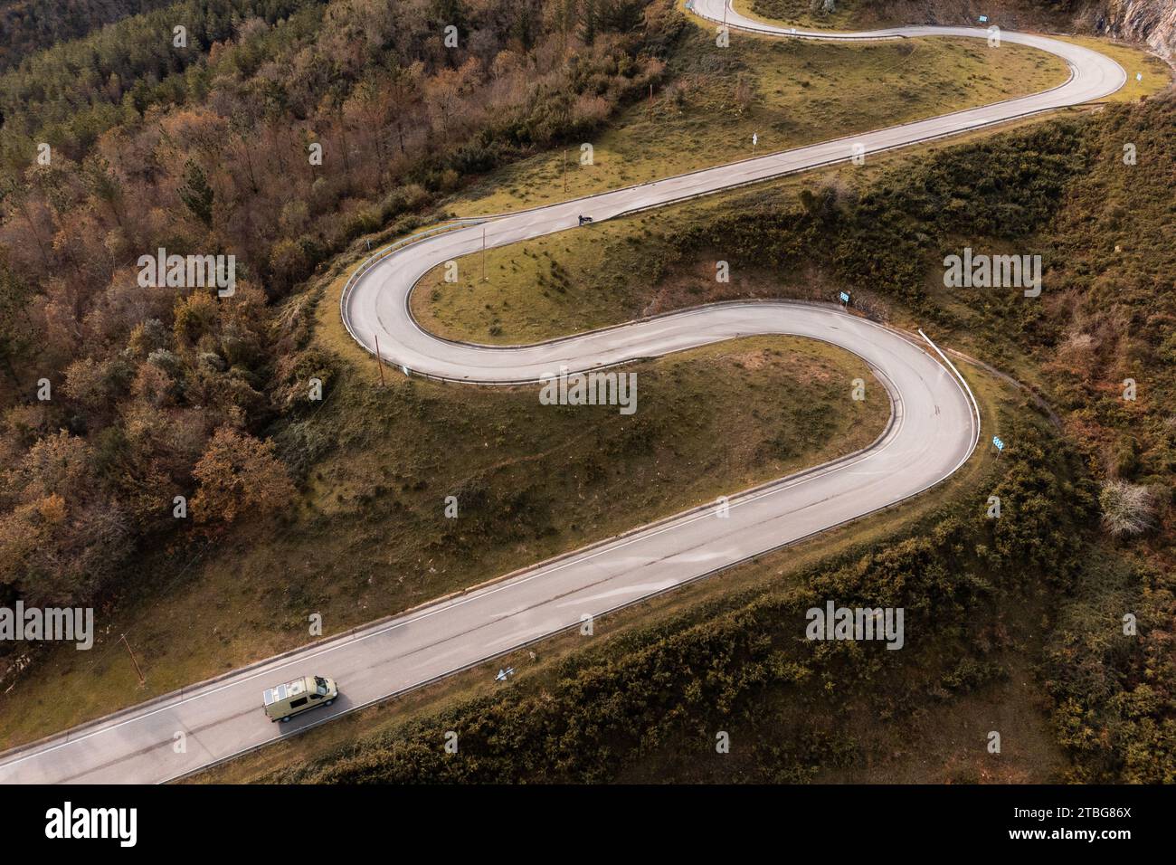 a camper van on a mountain road with many curves, ideal landscape ...