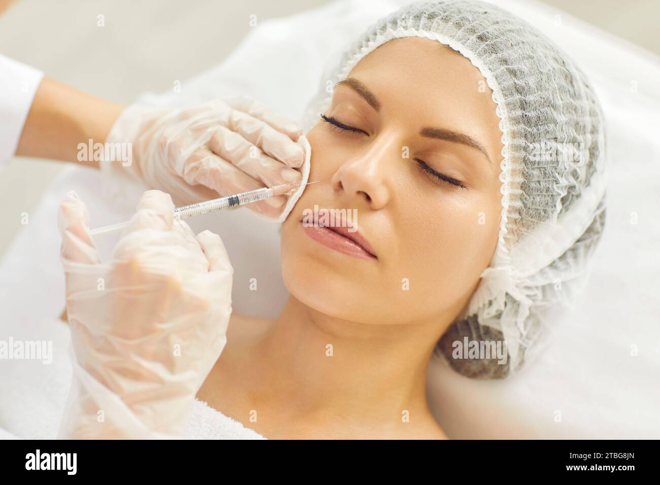 Woman receives nasolabial fold injection given by aesthetic medicine professional Stock Photo