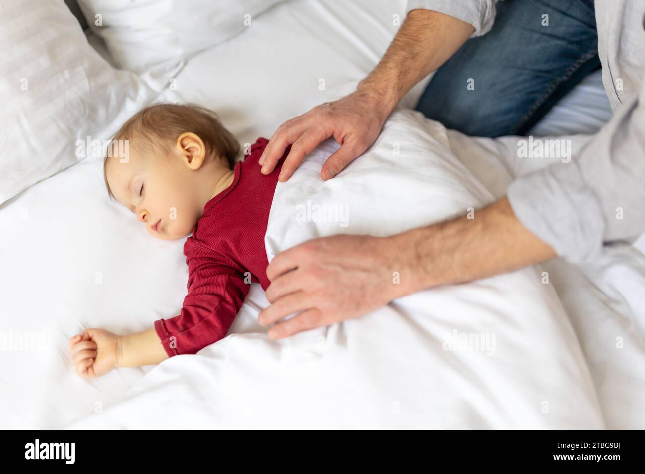 Father covering her sleeping baby with blanket at home Stock Photo Alamy