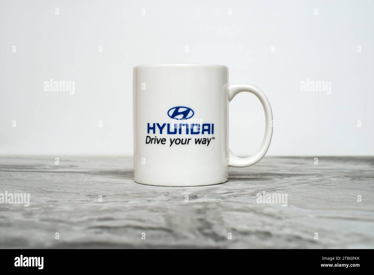 A branded white mug with the Hyundai logo and the slogan "Drive your ...