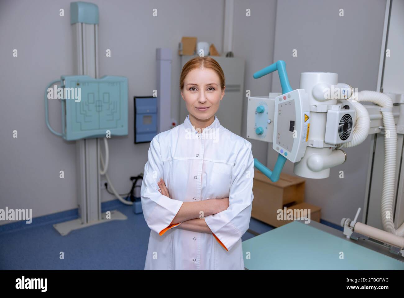 Caucasian blonde female doctor radiologist wearing lab coat posing near