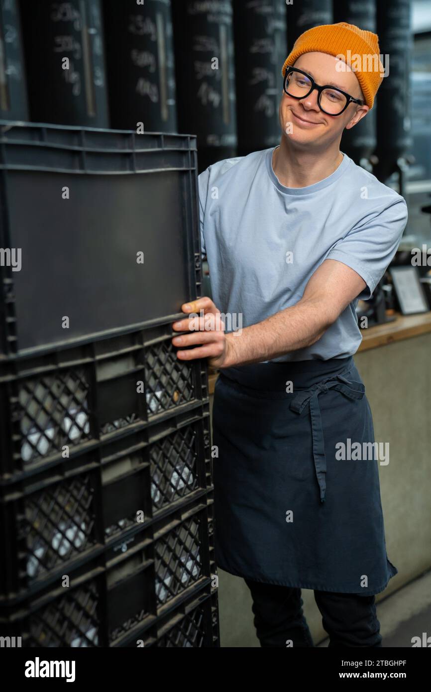 Barista bartender wearing hat and glasses unloads new batch of coffee