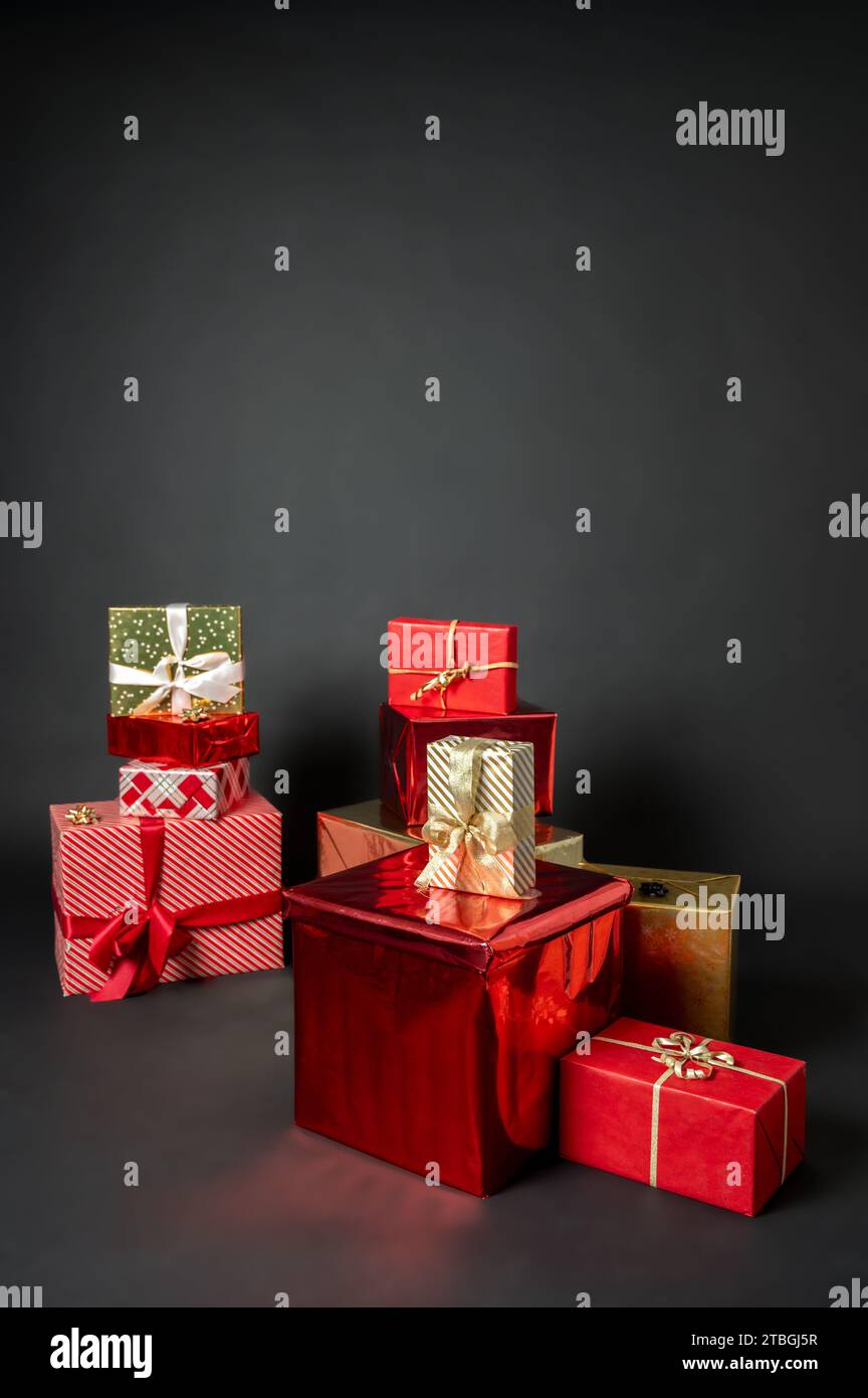 A lot of wrapped Christmas gift boxes. Red, white and golden color on black background Stock Photo