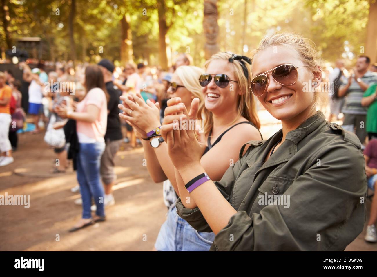 Woman, friends and outdoor crowd at music festival for summer holiday, celebration or party concert. Female person, clapping and community dancing in Stock Photo