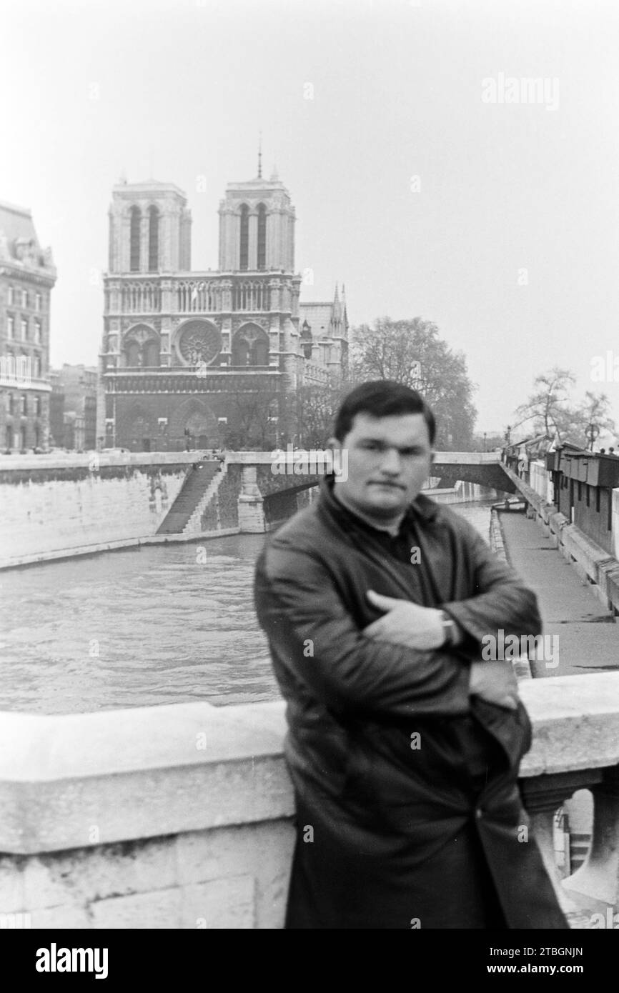Mann auf dem Pont Saint Michel, im Hintergrund die Kathedrale Notre Dame de Paris, 1965. Man on the Pont Saint Michel, Notre Dame de Paris Cathedral in the background, 1965. Stock Photo