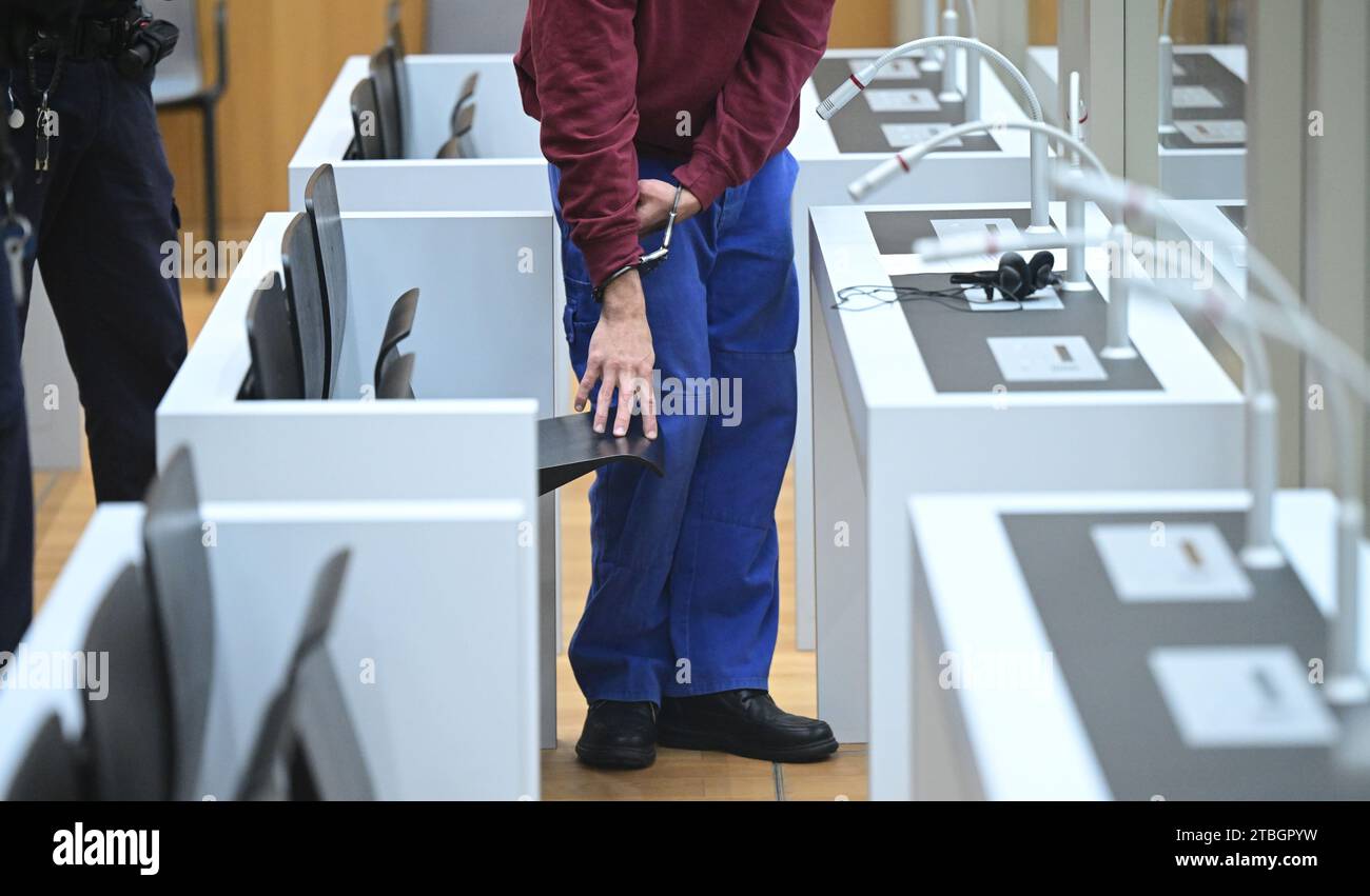 Stuttgart, Germany. 07th Dec, 2023. The defendant sits in his chair in a courtroom at the start of a trial for fifteen counts of attempted murder. Two rival groups have been waging a bloody feud in the Stuttgart area for many months, culminating in a hand grenade attack on a mourning congregation in Altbach near Esslingen. The Stuttgart public prosecutor's office has filed charges including attempted murder against the 23-year-old suspected grenade thrower. Credit: Bernd Weißbrod/dpa/Alamy Live News Stock Photo